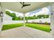 Covered patio with a ceiling fan overlooking a landscaped backyard and white privacy fence at 13702 Tranquil Day Dr, Matthews, NC 28105