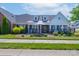 Charming brick home with a manicured lawn, black fence, and inviting front porch seating area at 148 Adelaide Way, Rock Hill, SC 29732