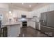 Modern kitchen featuring white cabinets, granite countertops, stainless steel appliances, and stylish pendant lighting at 148 Adelaide Way, Rock Hill, SC 29732