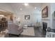 Open living room with a fireplace, modern lighting, and dark hardwood floors, leading into the kitchen at 148 Adelaide Way, Rock Hill, SC 29732