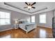 Bright bedroom featuring a tray ceiling, hardwood floors, and three large windows at 15430 Waterfront Dr, Huntersville, NC 28078