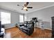 Cozy bedroom featuring a black leather love seat, ceiling fan and hardwood floors at 15430 Waterfront Dr, Huntersville, NC 28078
