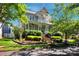Inviting two-story home with covered porch, landscaped yard, and mature trees under a sunny sky at 15430 Waterfront Dr, Huntersville, NC 28078