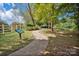 Scenic paved path through a green community park area with trees, grass, and a white fence at 15430 Waterfront Dr, Huntersville, NC 28078