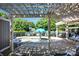 Relaxing view of the community pool and hot tub beneath a white pergola, surrounded by lush greenery at 15430 Waterfront Dr, Huntersville, NC 28078