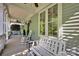 Cozy covered porch featuring rocking chairs, a bench, and ceiling fans for outdoor comfort at 15430 Waterfront Dr, Huntersville, NC 28078