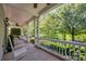 Relaxing covered porch area with white railings and comfortable seating overlooking lush greenery and trees at 15430 Waterfront Dr, Huntersville, NC 28078