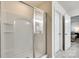 Bright white bathroom with a glass enclosed shower, tile floor, and open doorway at 1553 Arcadia Bluff Dr, York, SC 29745