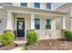 Inviting front porch with decorative columns, manicured shrubs and a beautifully landscaped garden bed at 1553 Arcadia Bluff Dr, York, SC 29745