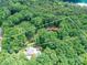 Aerial view of wooded land with a home and pool below; property is marked with a white outline at 167 Greenbay Rd, Mooresville, NC 28117