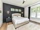 Stylish bedroom with a dark accent wall, modern lighting, and large windows offering plenty of natural light at 167 Greenbay Rd, Mooresville, NC 28117