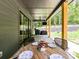 Relaxing covered patio perfect for outdoor dining with a wood table setting and nature views at 167 Greenbay Rd, Mooresville, NC 28117
