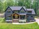 Stunning two-story home with dark siding, light-wood accents, manicured lawn, and inviting front porch at 167 Greenbay Rd, Mooresville, NC 28117