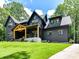 Beautiful two-story home featuring a dark exterior, a spacious lawn, and a charming front porch at 167 Greenbay Rd, Mooresville, NC 28117
