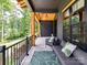 Charming front porch with comfortable seating, a patterned rug, and views of the surrounding woods at 167 Greenbay Rd, Mooresville, NC 28117