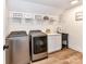 Modern laundry room with stainless steel washer and dryer, sink, and plenty of storage at 167 Greenbay Rd, Mooresville, NC 28117