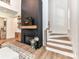Cozy living room featuring a modern fireplace with wood mantle, adjacent staircase, and hardwood flooring at 167 Greenbay Rd, Mooresville, NC 28117