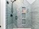 Close up of a shower with sleek gray tile, built-in niches, and modern fixtures at 167 Greenbay Rd, Mooresville, NC 28117