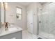 Bathroom featuring marble tiling, a glass shower stall, and double vanity sinks at 1813 Shelbourne Way, Fort Mill, SC 29707
