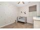 Bright bedroom features hardwood floors, a ceiling fan and a cozy crib beside a window with neutral blinds at 1813 Shelbourne Way, Fort Mill, SC 29707