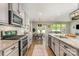 Open kitchen with stainless steel appliances, granite counters, breakfast area and view to the living area at 1813 Shelbourne Way, Fort Mill, SC 29707