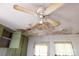 Damaged ceiling tile with visible water damage above kitchen cabinets and curtains offers renovation potential at 208 N School St, Mount Gilead, NC 27306
