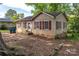 Tan single-story house with red shutters and partial brick foundation at 208 N School St, Mount Gilead, NC 27306