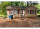 Charming tan single-story home with red shutters and front yard at 208 N School St, Mount Gilead, NC 27306