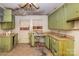 Vintage kitchen needing renovation, featuring olive cabinets, curtains and a double sink, presents a remodeling opportunity at 208 N School St, Mount Gilead, NC 27306