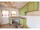 Vintage kitchen needing renovation, featuring olive cabinets, curtains and a double sink, presents a remodeling opportunity at 208 N School St, Mount Gilead, NC 27306