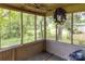 This porch has a floral wreath, and several windows overlooking the wooded property at 208 N School St, Mount Gilead, NC 27306
