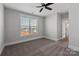 A serene bedroom features neutral tones, a ceiling fan, and a window offering neighborhood views at 2092 Fordhill St, Rock Hill, SC 29732