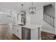 A stylish kitchen features a large island with a dishwasher and pendant lighting, and stairs in the background at 2092 Fordhill St, Rock Hill, SC 29732