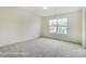Bright bedroom featuring a large window with neighborhood views and neutral carpeting at 2233 Tabor Rd # 586, Sherrills Ford, NC 28673