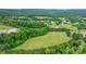 An aerial view showcasing the property's lush greenery and expansive landscape with mature trees on a bright day at 2448 Moss Farm Rd, Hickory, NC 28602
