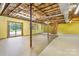 Bright unfinished basement with exposed ceiling, support beams, painted yellow walls, and sliding glass doors at 2448 Moss Farm Rd, Hickory, NC 28602