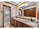 Bathroom featuring double sinks with granite countertops, a large mirror, and wood cabinets at 2448 Moss Farm Rd, Hickory, NC 28602