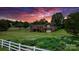 Brick home surrounded by a colorful flower garden and white fencing at 2448 Moss Farm Rd, Hickory, NC 28602