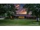 Charming brick home featuring a well-manicured lawn and beautiful landscaping under an orange sunset at 2448 Moss Farm Rd, Hickory, NC 28602
