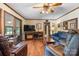 Open-concept living room with wood floors, entertainment center, and access to the sunroom at 2448 Moss Farm Rd, Hickory, NC 28602