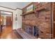 Living room featuring a charming brick fireplace, wood flooring, wood accent, and a glimpse of the entry way at 2448 Moss Farm Rd, Hickory, NC 28602