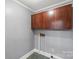 Laundry room with dark wood cabinets, gray walls, and green and gray flooring at 24515 Saint Martin Rd, Albemarle, NC 28001