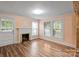 Inviting living room featuring a fireplace, hardwood floors, and natural light from the windows at 24515 Saint Martin Rd, Albemarle, NC 28001