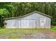 Exterior view of the gray metal outbuilding with a sliding door and gravel driveway at 24515 Saint Martin Rd, Albemarle, NC 28001