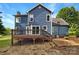 Backyard view showcasing the home's blue siding, a wooden deck, and a well-maintained lawn at 2532 Steeplechase Rd, Gastonia, NC 28056