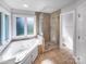 Bathroom featuring a glass shower enclosure, soaker tub, tile flooring, and window at 2532 Steeplechase Rd, Gastonia, NC 28056