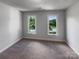 Neutral bedroom with carpet and two bright windows with exterior landscape views at 2532 Steeplechase Rd, Gastonia, NC 28056