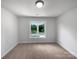 This is a minimalistic bedroom featuring a large window offering plenty of natural light and a neutral carpet at 2532 Steeplechase Rd, Gastonia, NC 28056