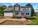 Charming two-story home with blue siding, stone accents, well-manicured landscaping, and an attached two-car garage at 2532 Steeplechase Rd, Gastonia, NC 28056