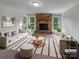 Bright living room with stone fireplace, large windows, neutral decor, and stylish furnishings at 2532 Steeplechase Rd, Gastonia, NC 28056